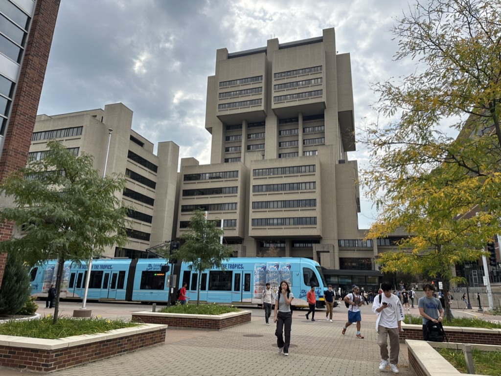 Malcom Moos Health Sciences Tower from the north with light rail train in front